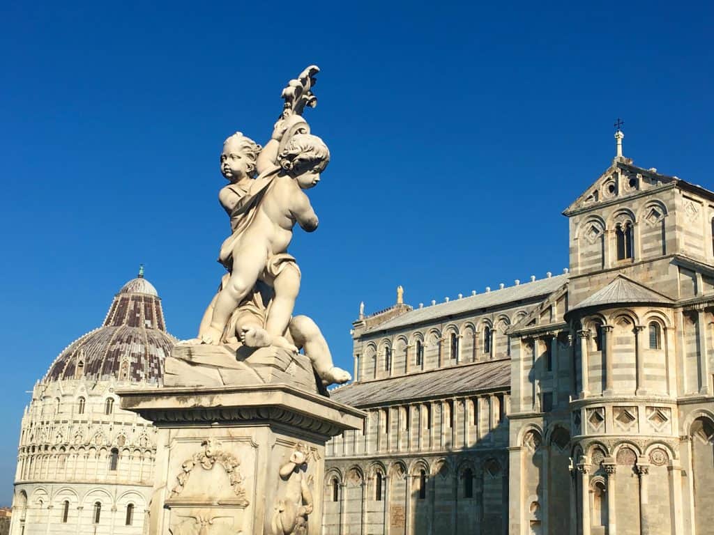 Statue of cherubs with Pisa Cathedral in background