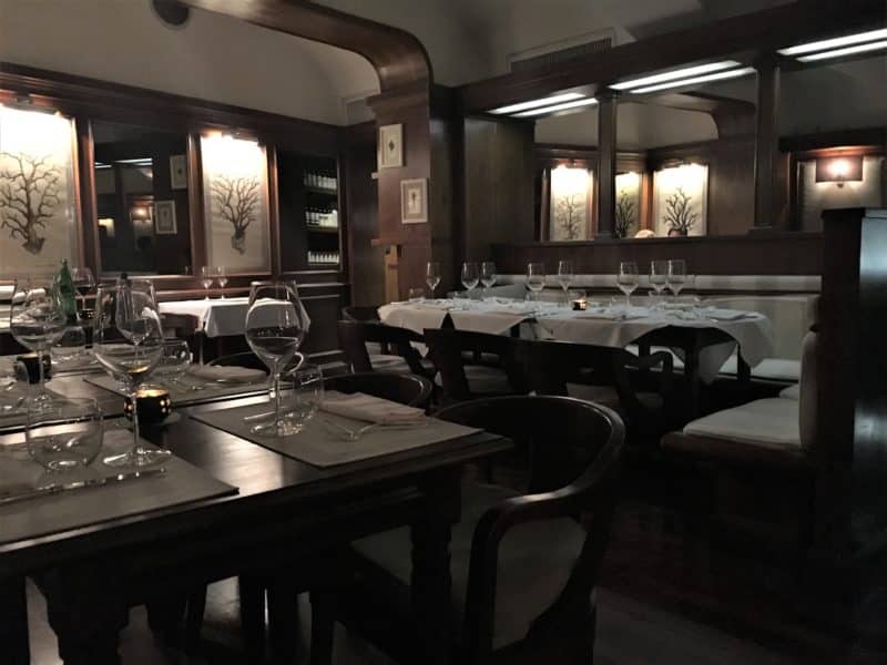 The dark wood decor and set tables with cutlery and wine glasses of Il Barretto.