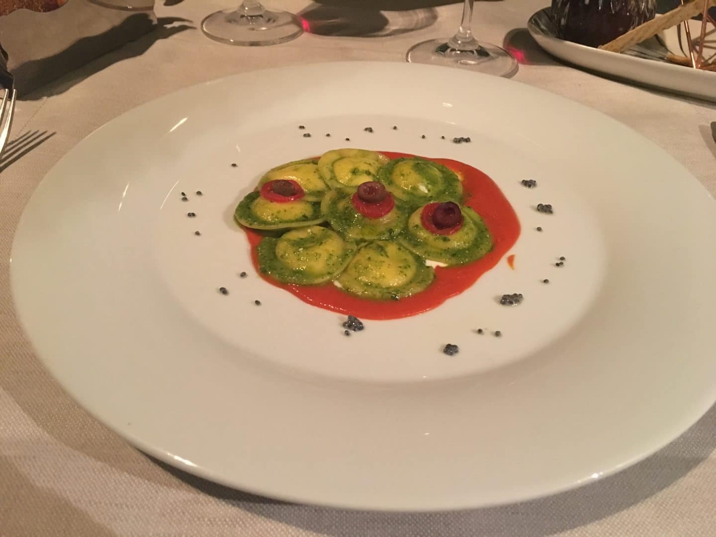 Locale Firenze restaurant green Ravioli stuffed with Burrata in a tomato sauce on a white plate