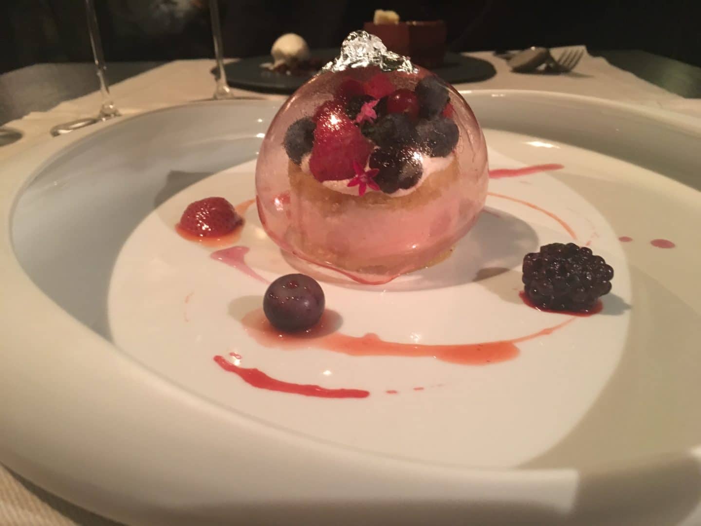 Locale Firenze Sugar encapsulated lime cake with blackberries and a berry jus, served on a bright white plate.