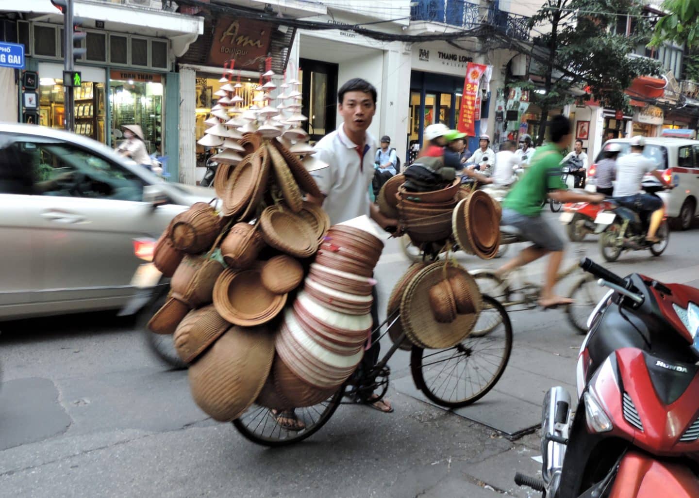 Man carrying hates on bike in Hanoi