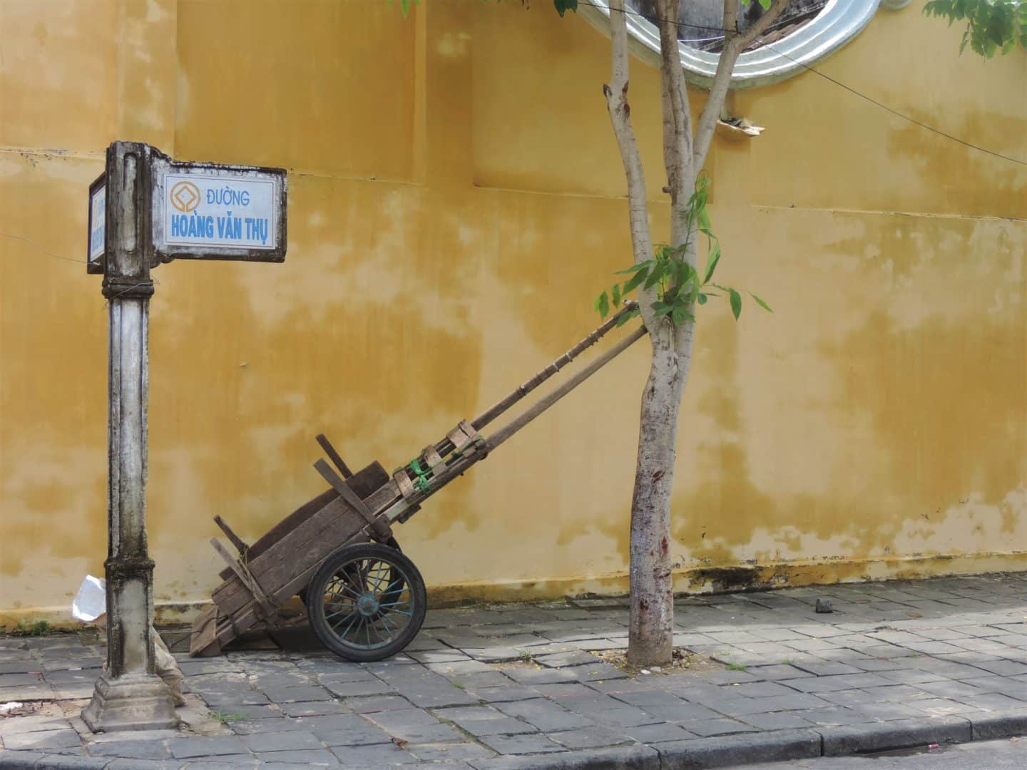 Wheel barrow with yellow wall in Hoi An