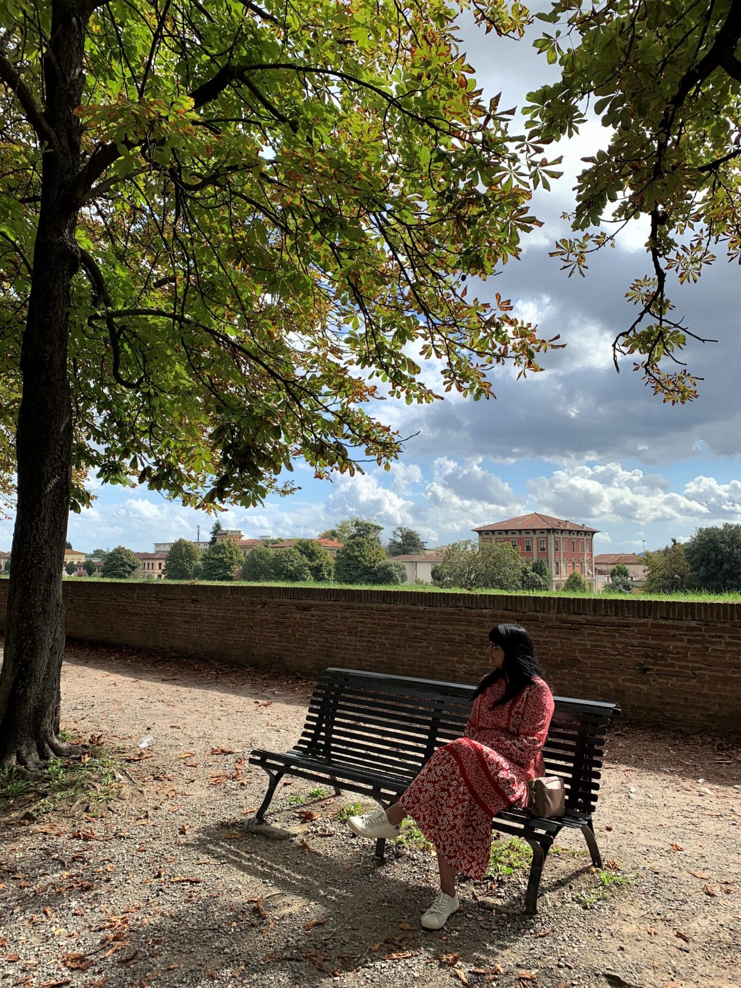 Bejal sitting on bench along city walls, Lucca