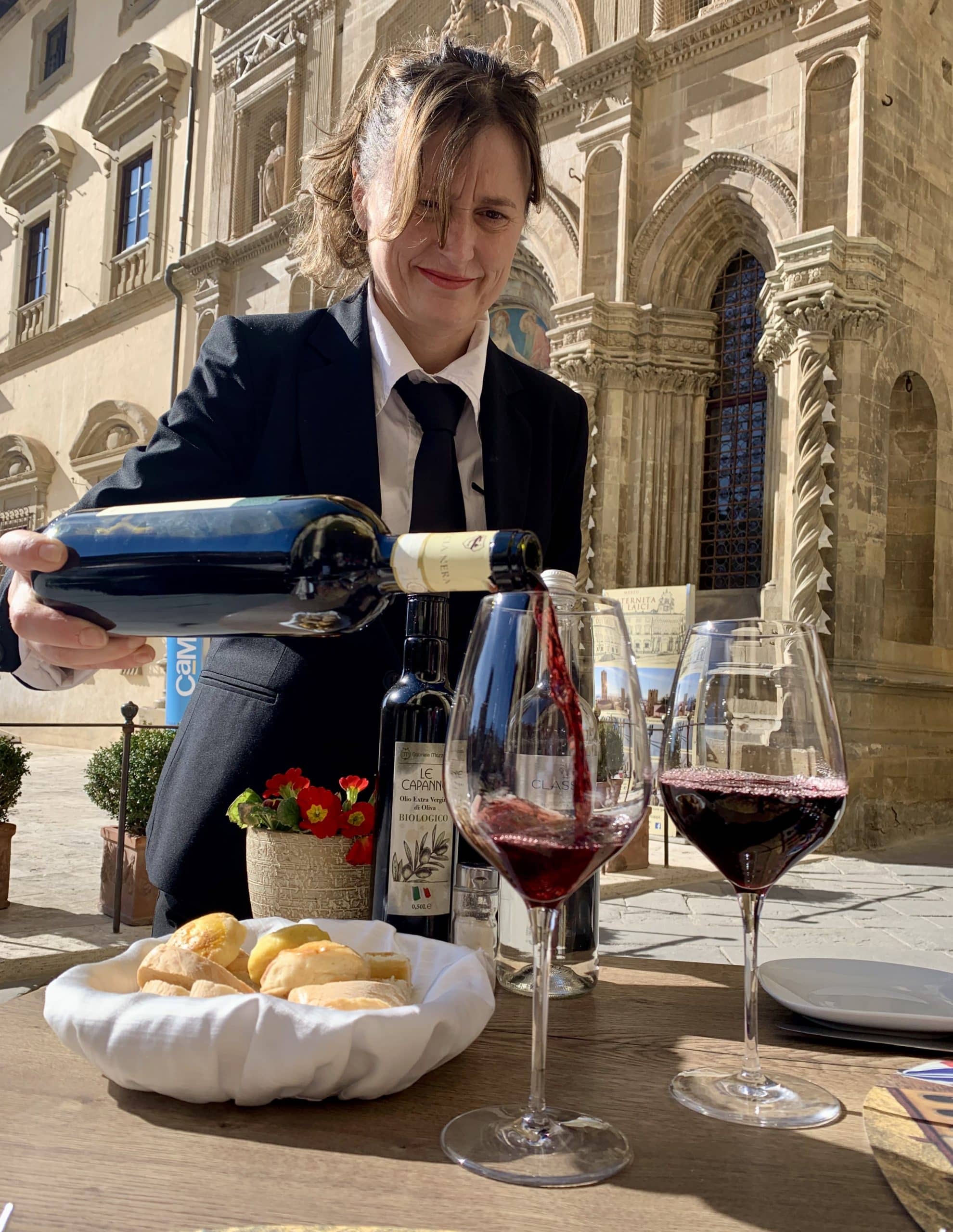 Waitress pouring wine in Piazzale Grande