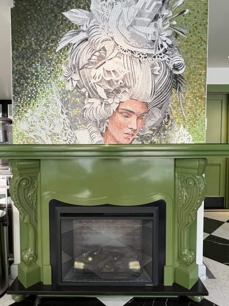 green fire place at Staypineapple hotel in Boston with art work