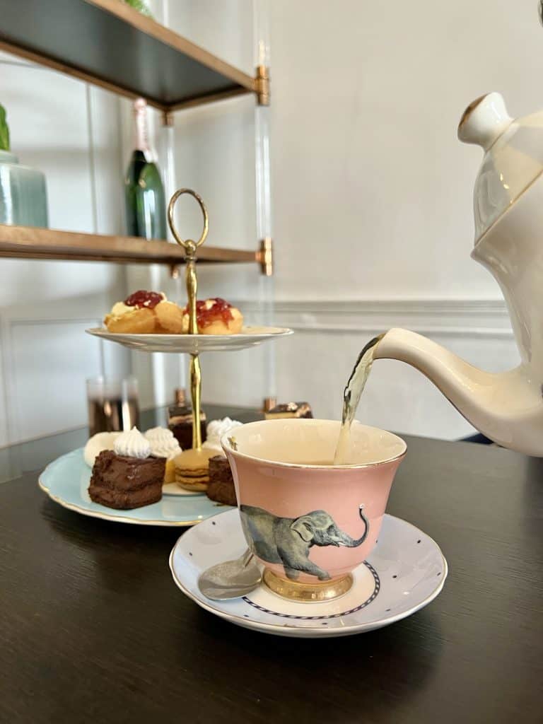 Tea pouring with cake stand in background