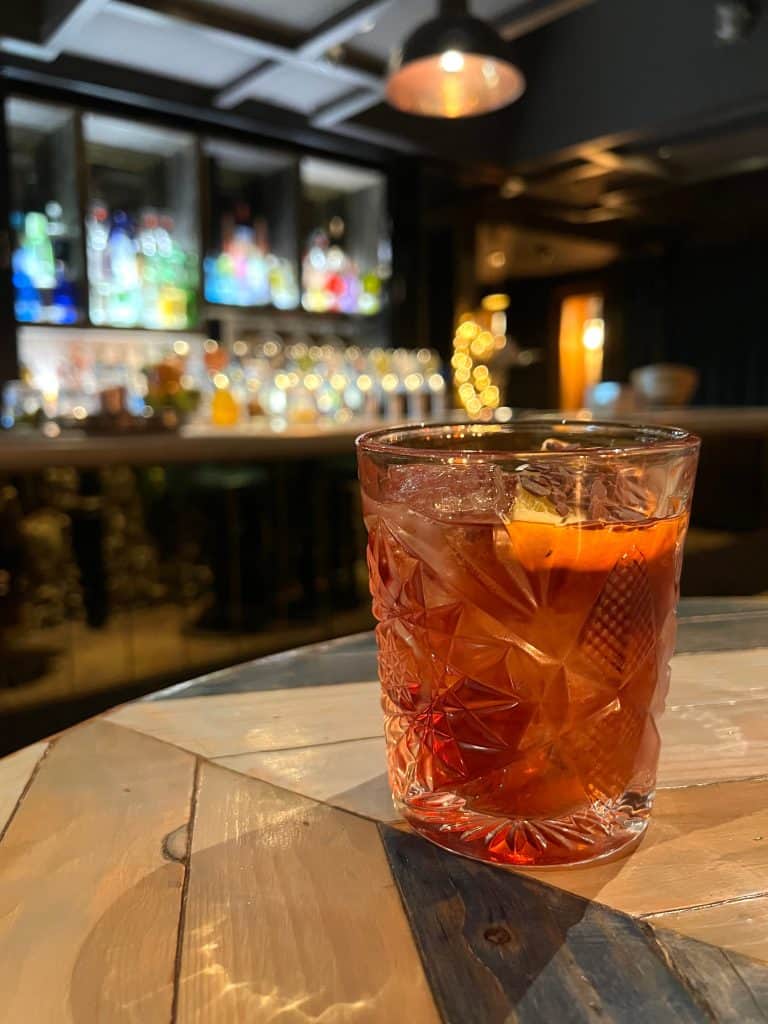 A negroni at the hotel bar with drinks in the background