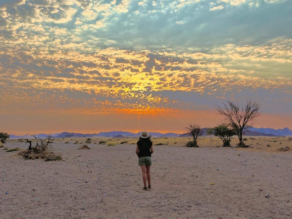 Best visit Sossusvlei: Bejal standing on Desert Homestead reserve watching the sunset