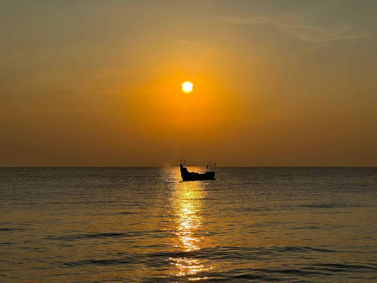 Sunset with fishing boat in the sea on Marari Beach